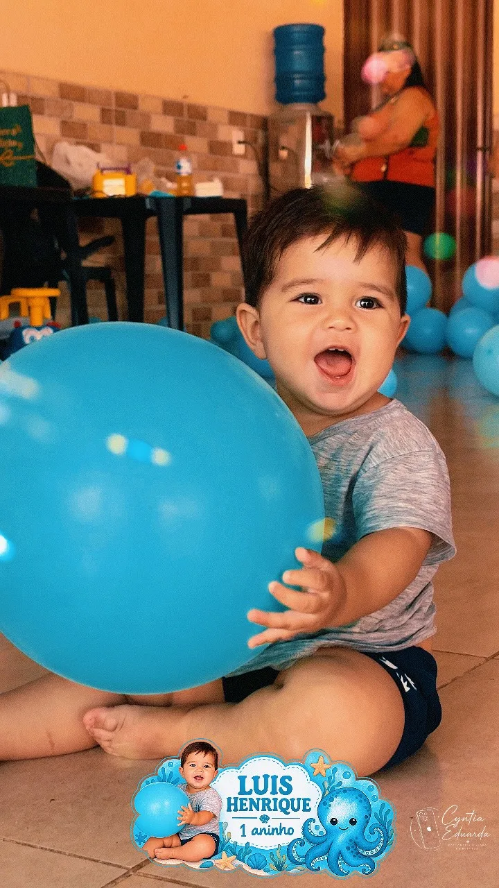 Criança sentada segura um balão azul em um ambiente decorado para festa.